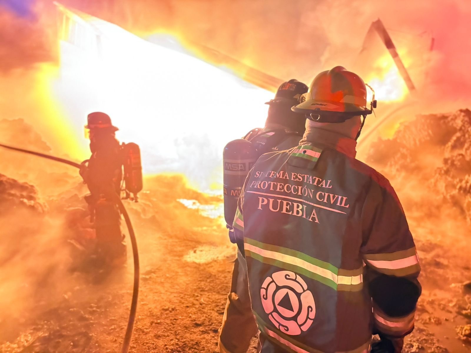 Evacúan viviendas por incendio en bodega de reciclaje en la capital poblana